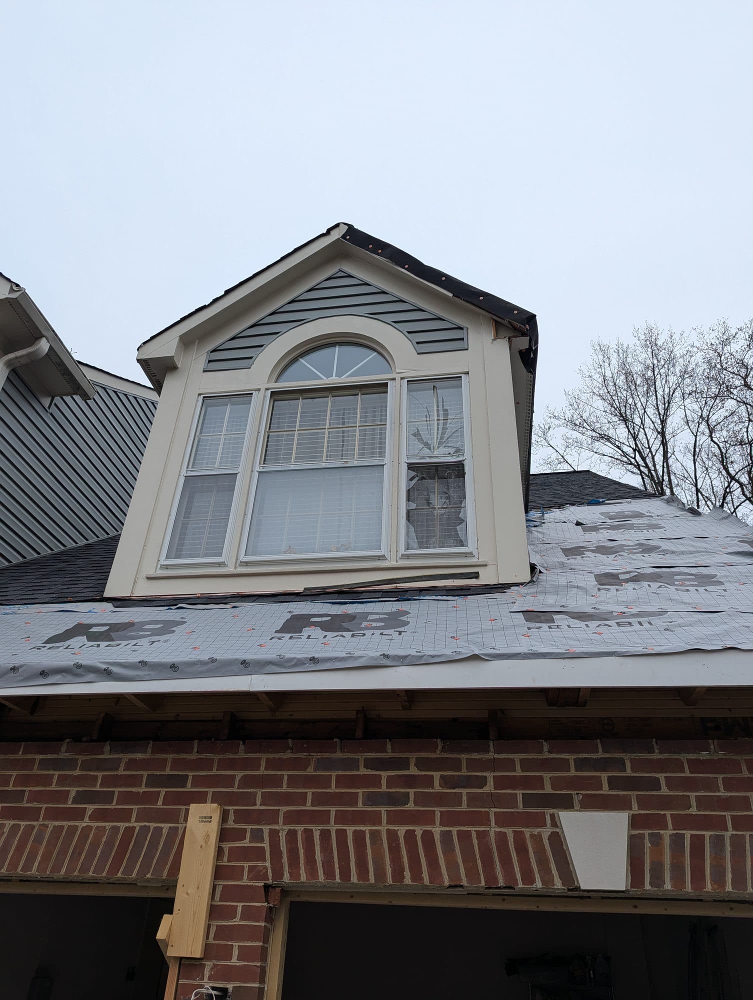 Dormer window with new synthetic underlayment installed, ready for shingles