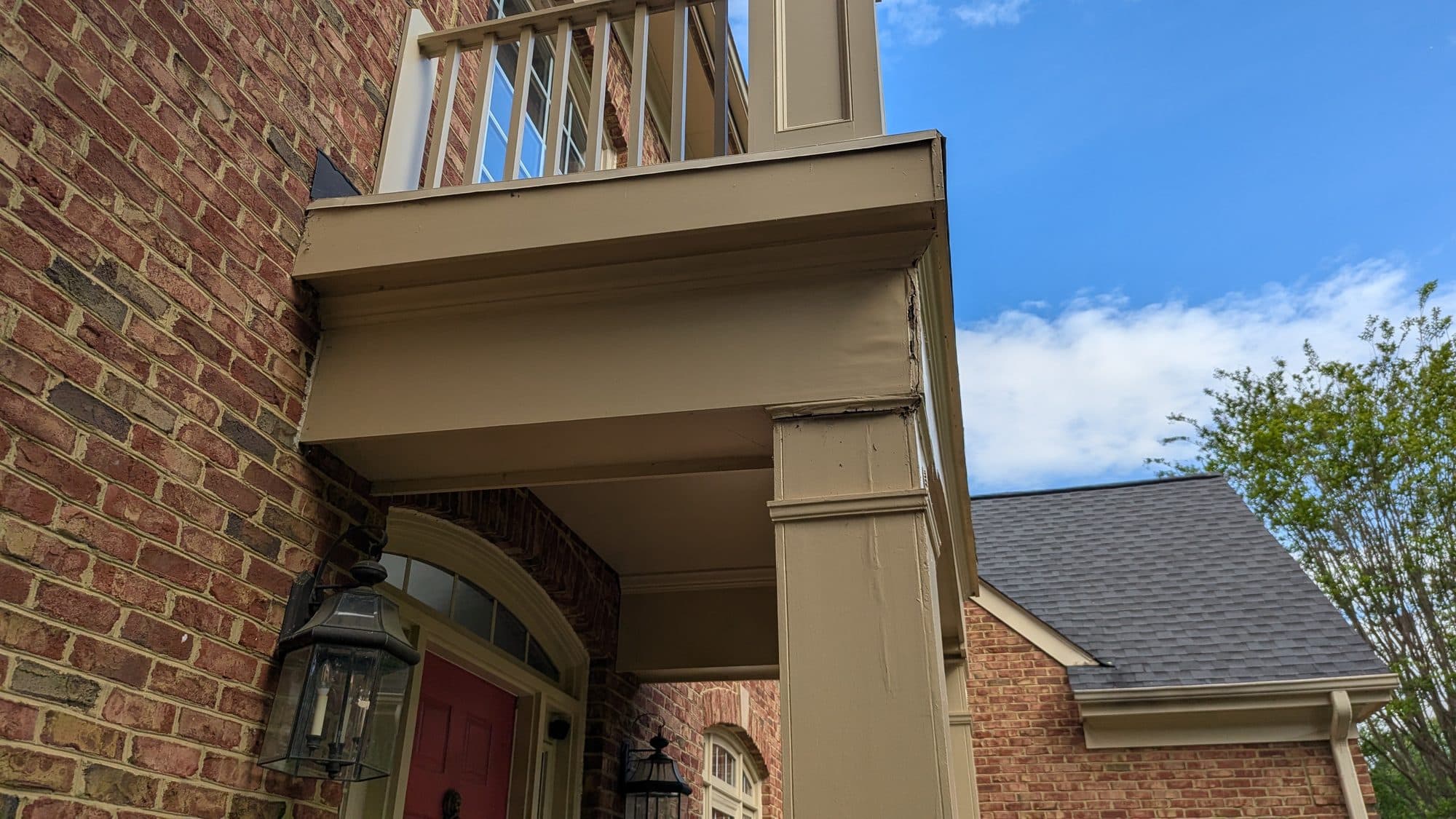 Close-up of a repaired flat roof over a covered front porch and balcony